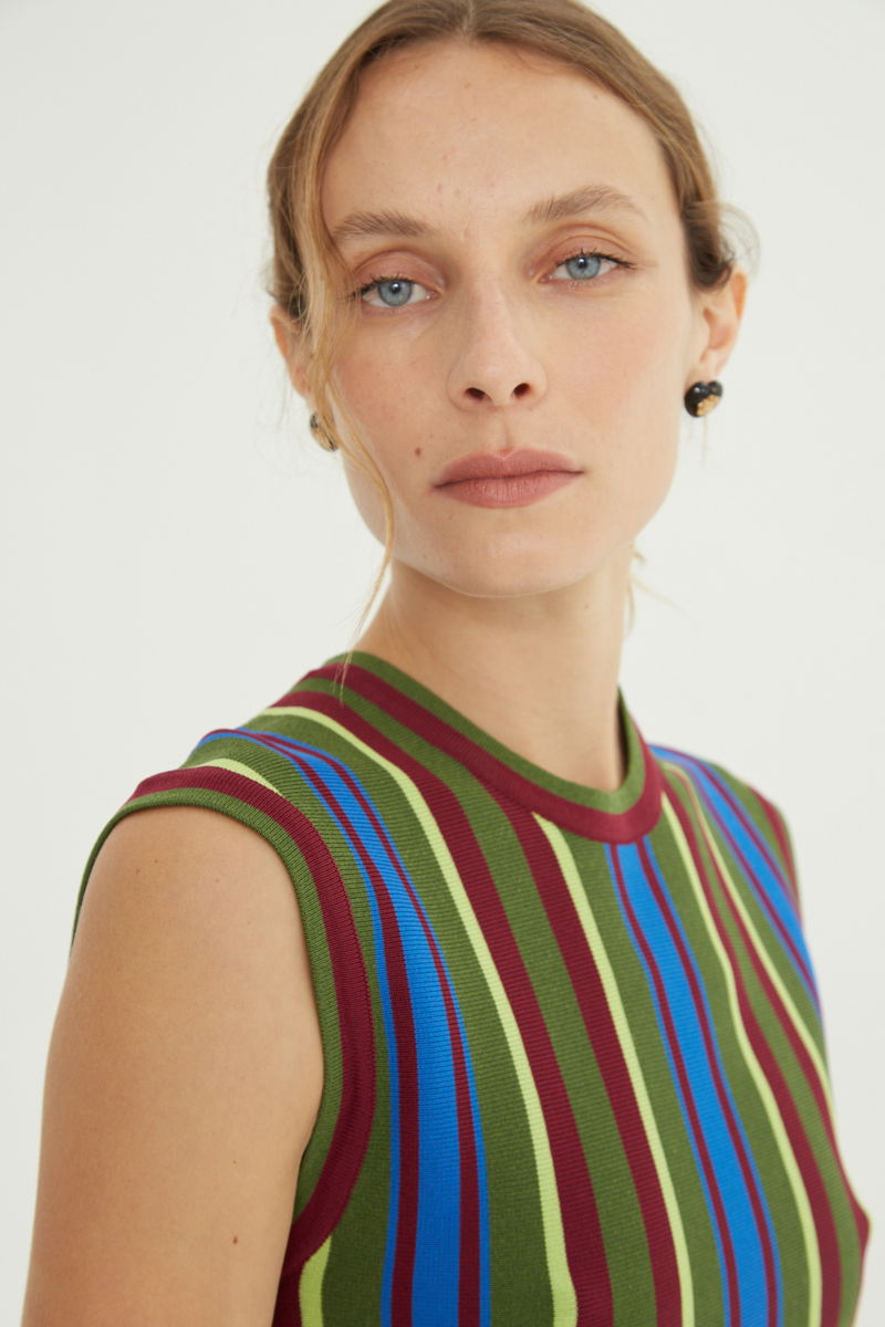 Musculosa verde tejida a rayas de cuello redondo, calce recto y larga hasta la cadera con aberturas laterales.