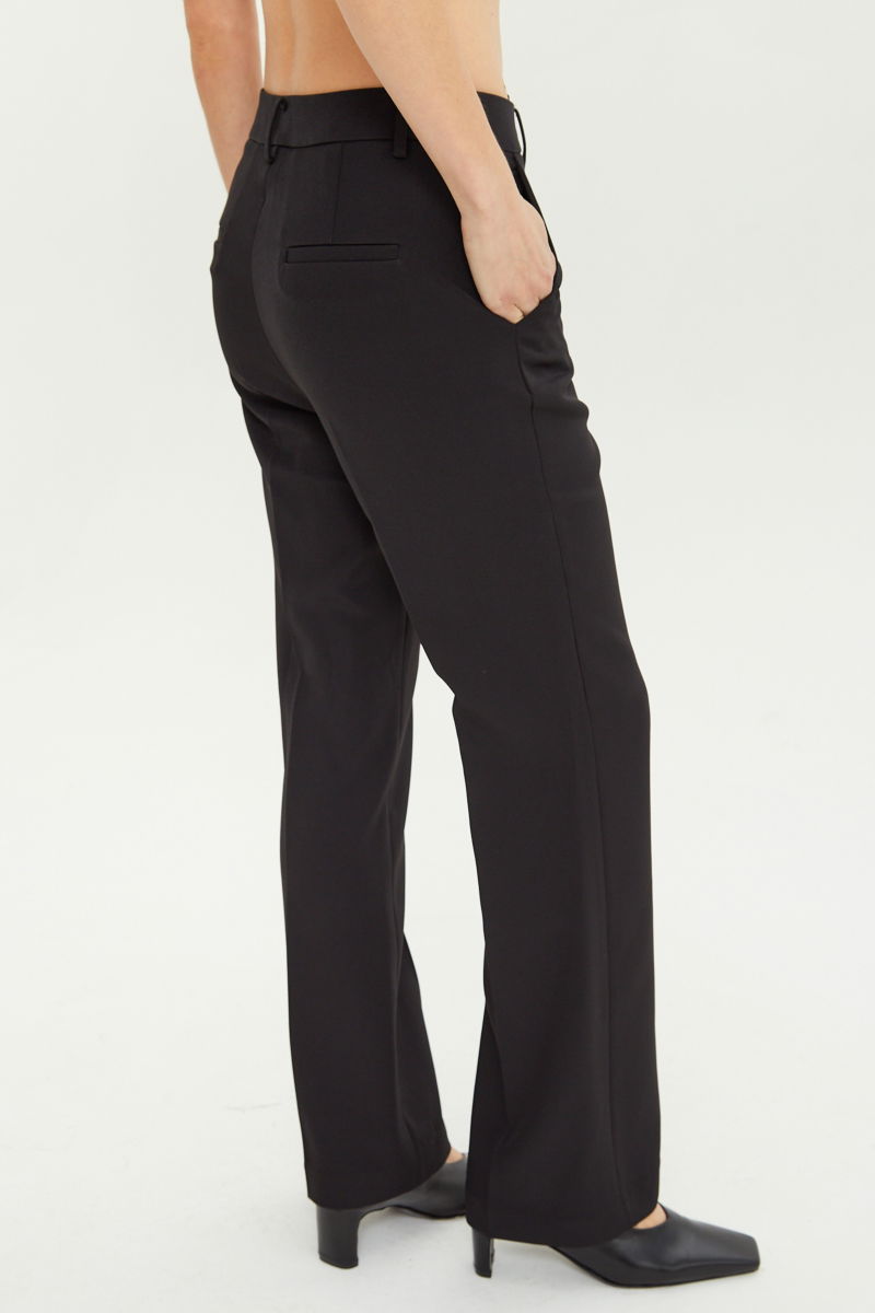 Pantalón negro sastrero tiro alto de corte recto y largo al tobillo con pinzas en el frente, bolsillos laterales y bolsillo ojal en la espalda. 
