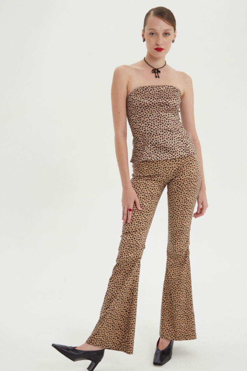 Pantalón elastizado con estampa animal print, tiro bajo y de corte acampanado con cierre invisible lateral y pinzas traseras.