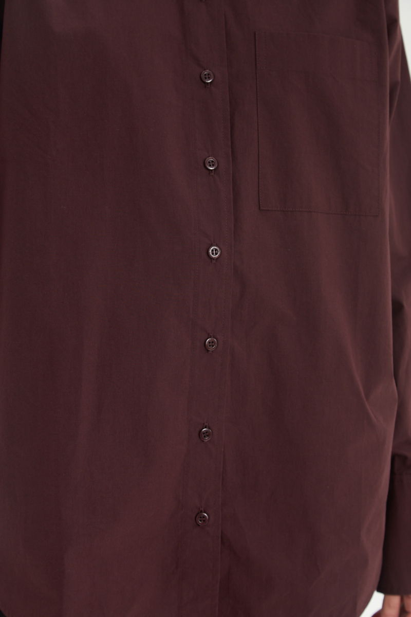 Camisa uva oversize de poplín de algodón larga por debajo de la cadera con bolsillo aplicado al frente, tabla en la espalda y botones a tono.