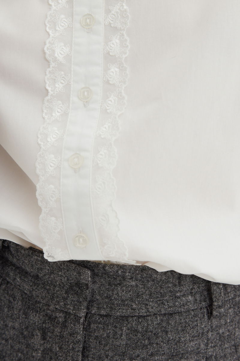 Camisa blanca de algodón recta con cuello mao y terminaciones de encaje en cuello, puños, cartera y canesú. 
