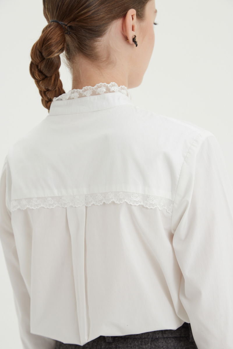 Camisa blanca de algodón recta con cuello mao y terminaciones de encaje en cuello, puños, cartera y canesú. 
