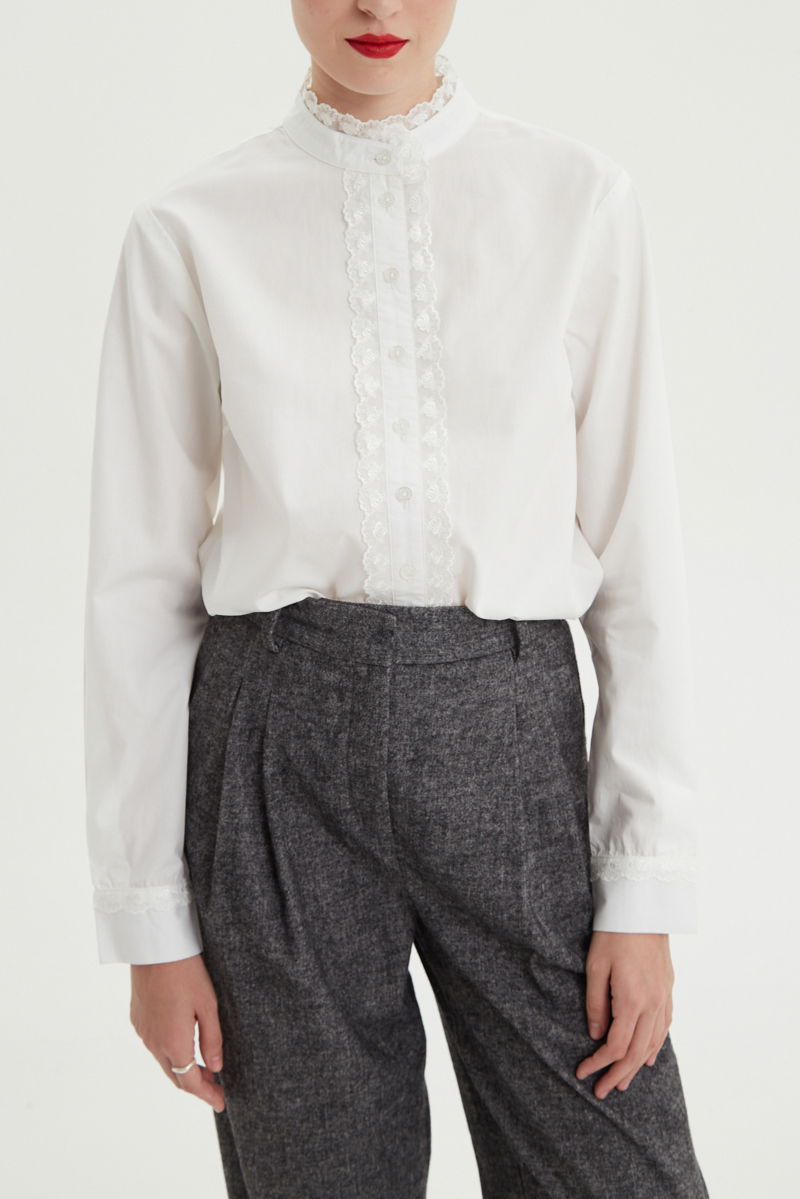 Camisa blanca de algodón recta con cuello mao y terminaciones de encaje en cuello, puños, cartera y canesú. 
