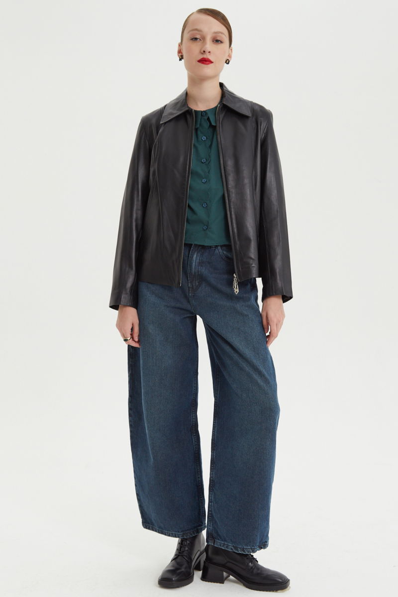 Camisa verde de poplin de largo hasta la cadera con terminación en forma de onditas en cuello, puños y cartera y botones a tono en forma de flor. 