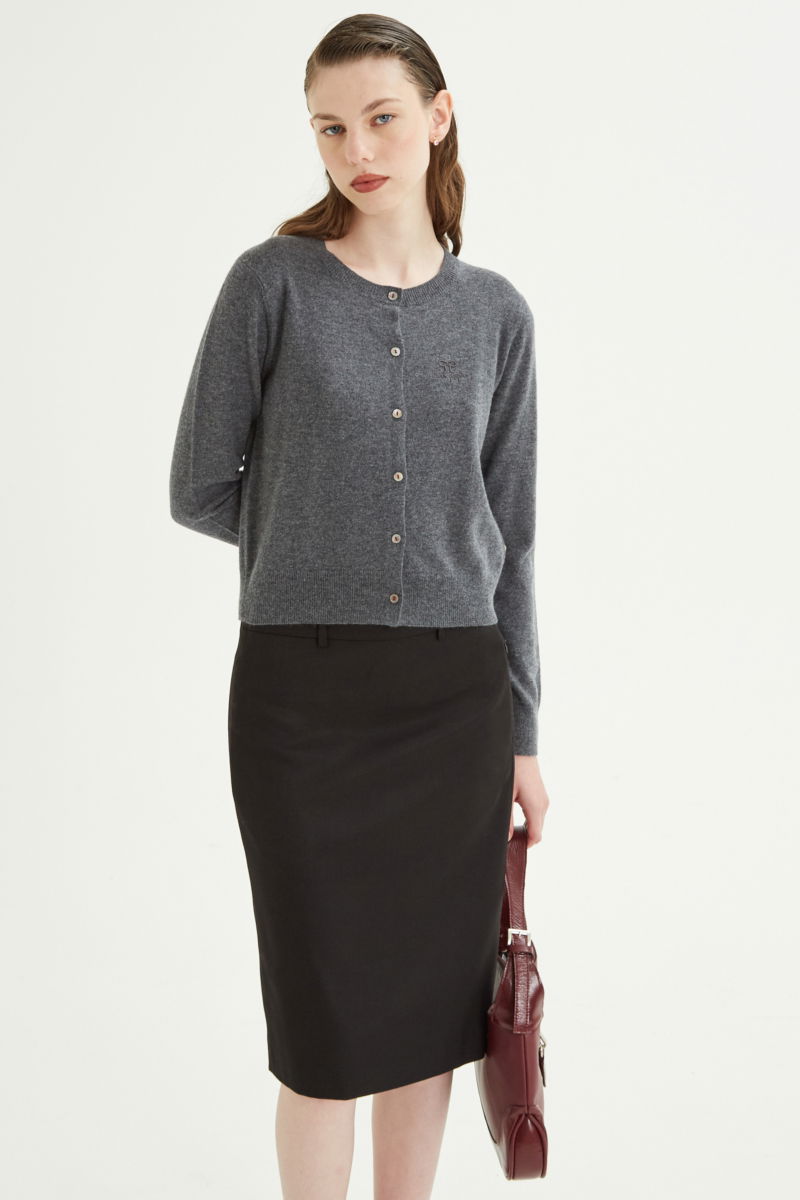 Cardigan gris de lana y cachemira de corte recto entallado en la cintura con terminaciones en rib en puños y ruedo, cuello redondo cerrado y botones a tono.