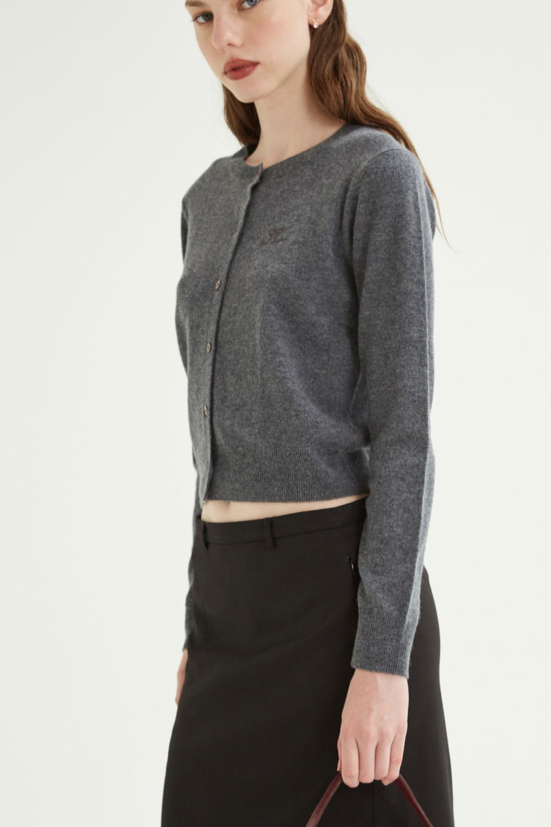 Cardigan gris de lana y cachemira de corte recto entallado en la cintura con terminaciones en rib en puños y ruedo, cuello redondo cerrado y botones a tono.