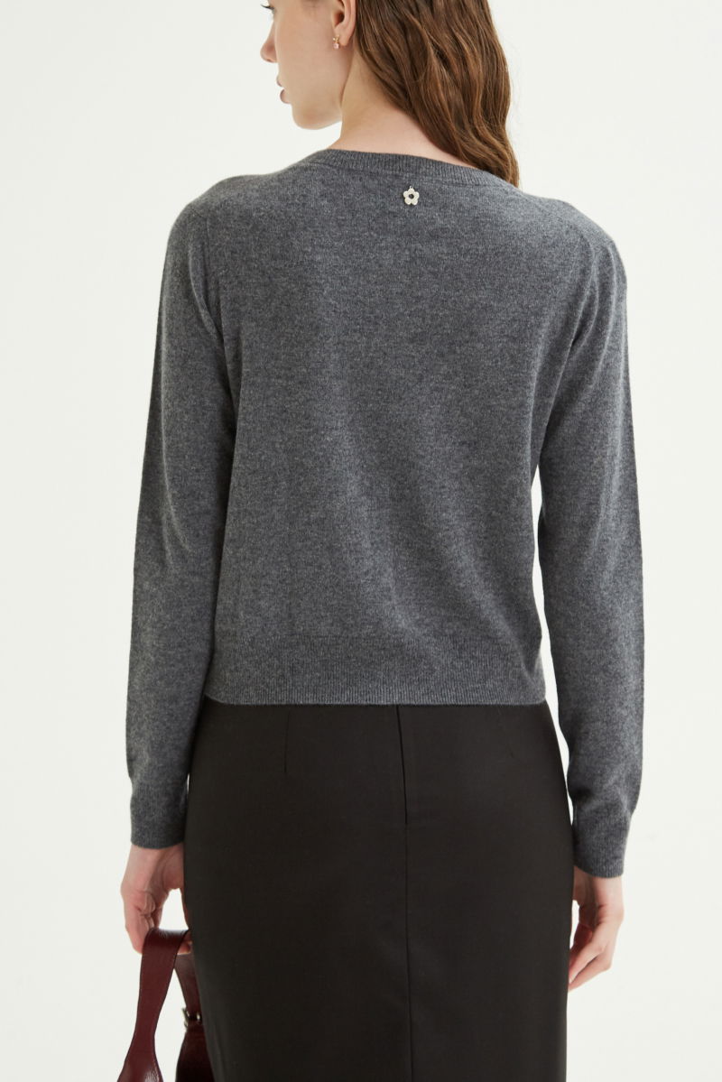 Cardigan gris de lana y cachemira de corte recto entallado en la cintura con terminaciones en rib en puños y ruedo, cuello redondo cerrado y botones a tono.