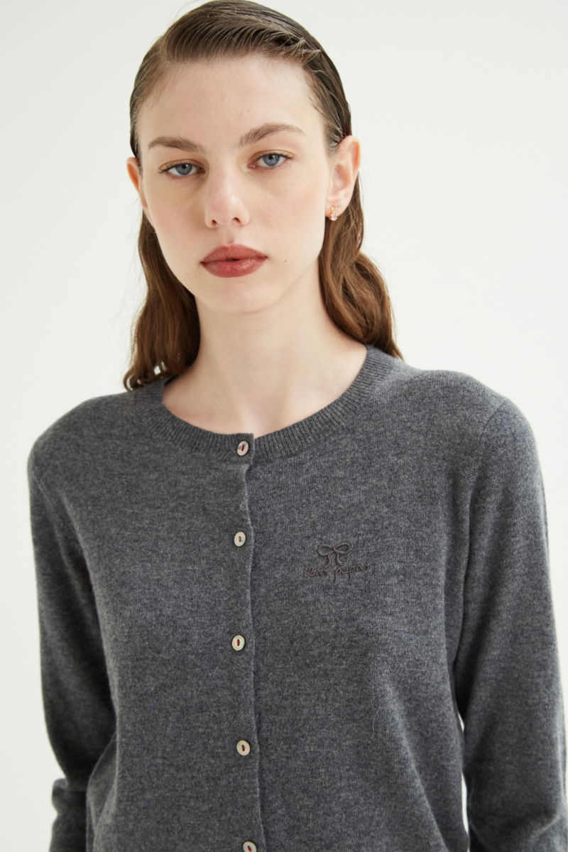 Cardigan gris de lana y cachemira de corte recto entallado en la cintura con terminaciones en rib en puños y ruedo, cuello redondo cerrado y botones a tono.