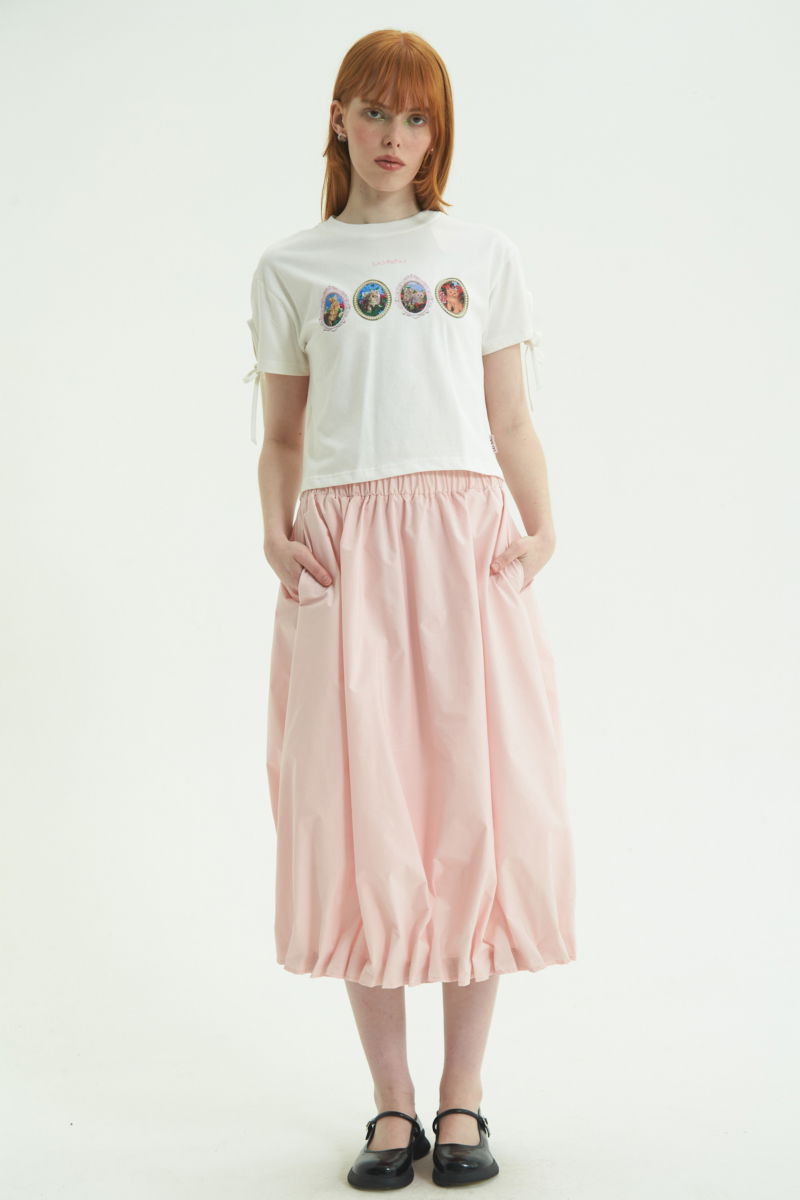 Remera blanca suelta y crop de algodón estampada con lazos en las mangas para atar en moño.
