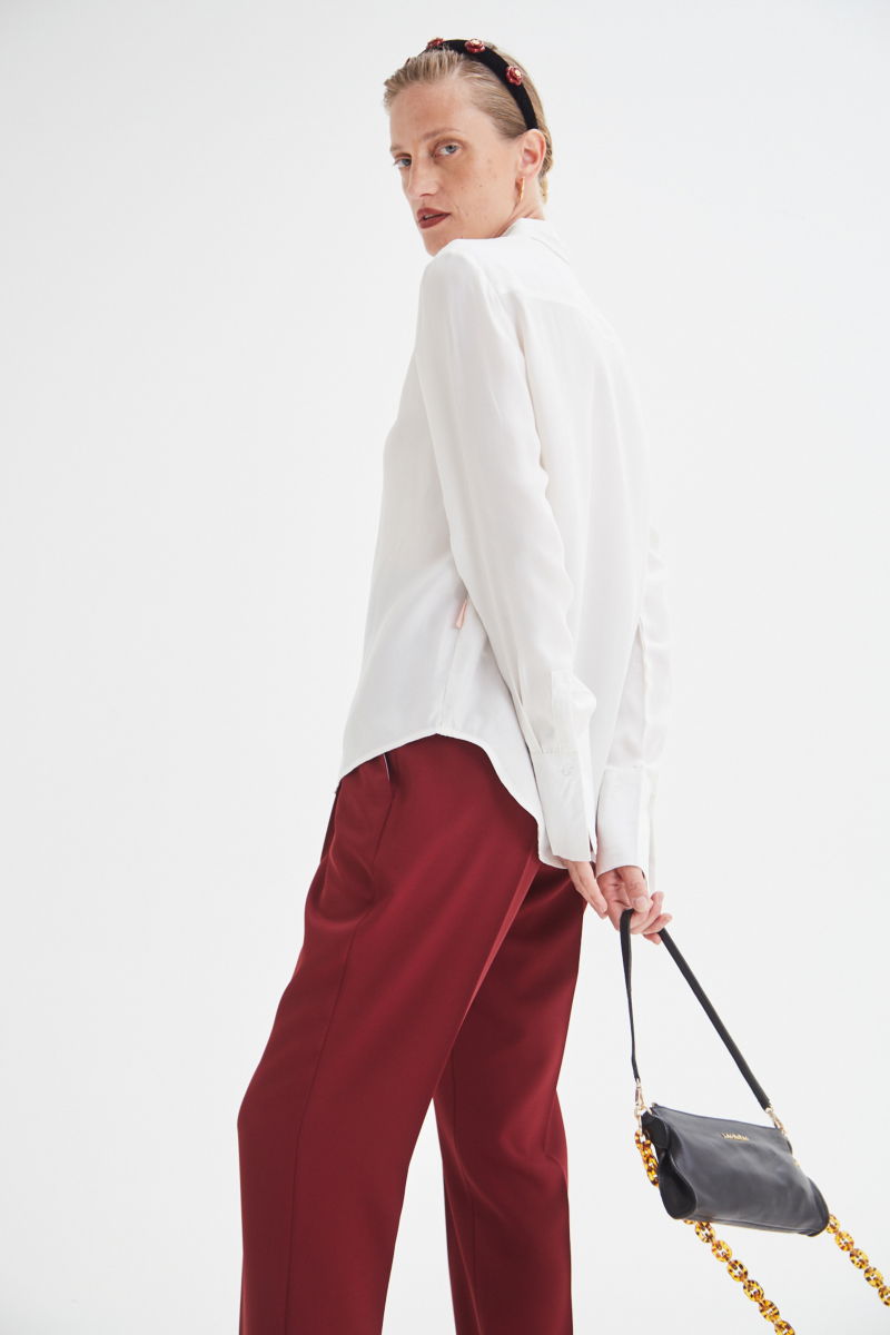 Camisa blanca de calce recto y puños anchos con textura suave de piel de durazno. 
