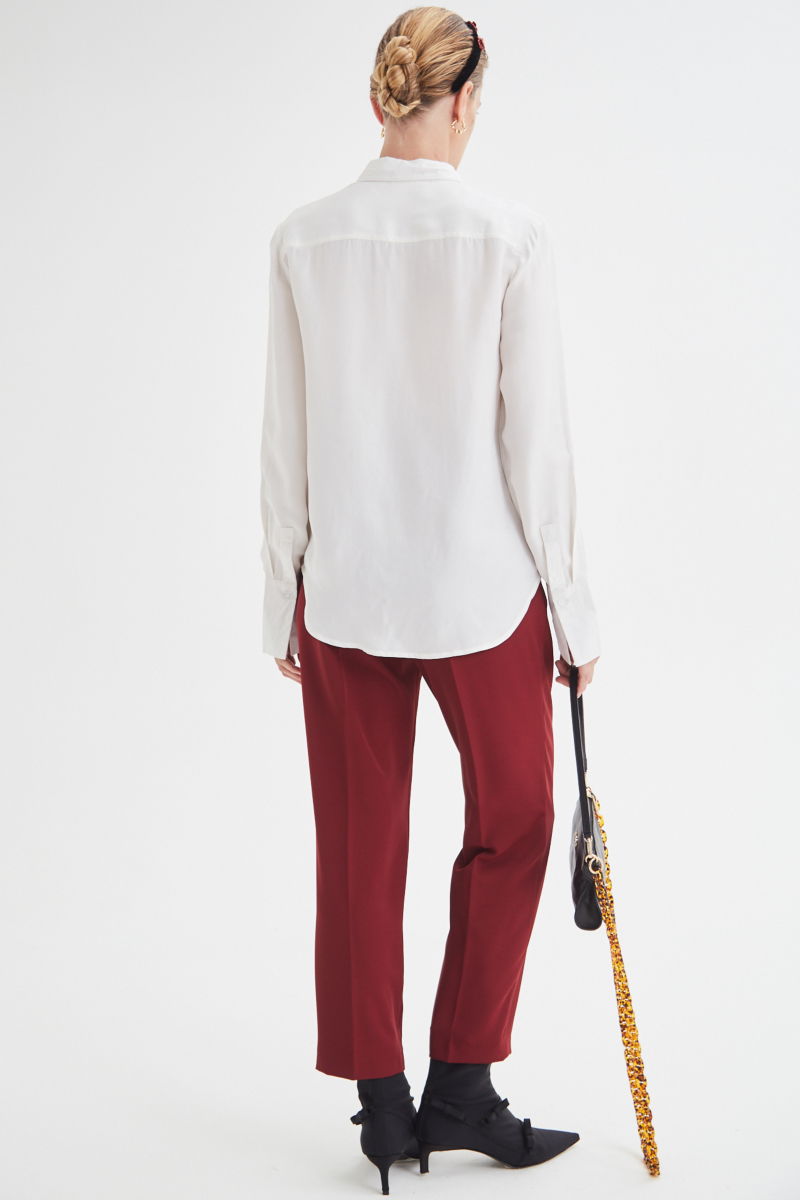 Camisa blanca de calce recto y puños anchos con textura suave de piel de durazno. 
