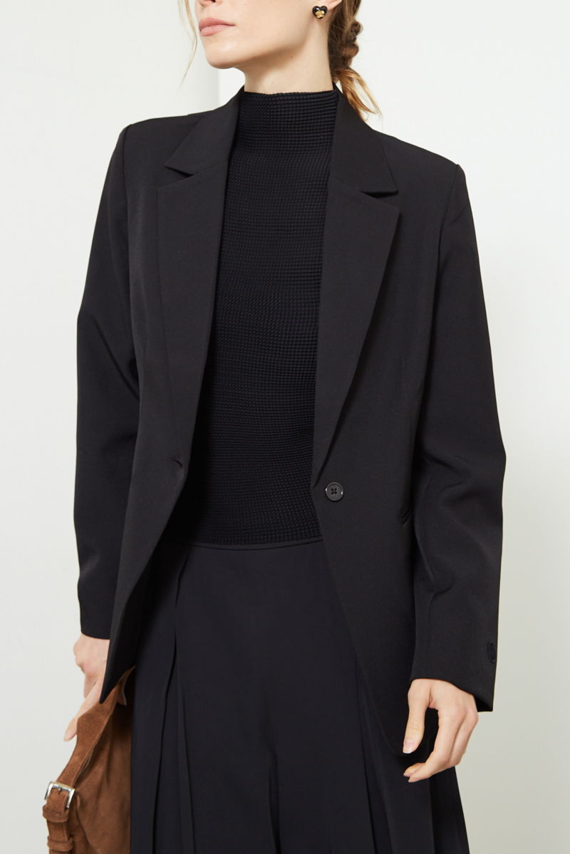 Blazer negro sastrero recto con hombreras, bolsillos ojal y pinzas en frente y espalda. 
