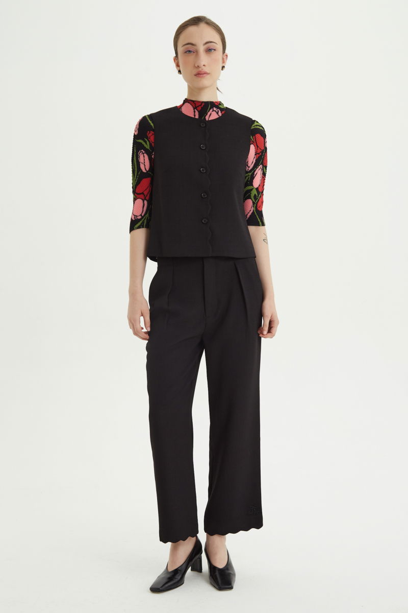 Pantalón negro sastrero recto tiro medio con terminación ondulada en el ruedo.
