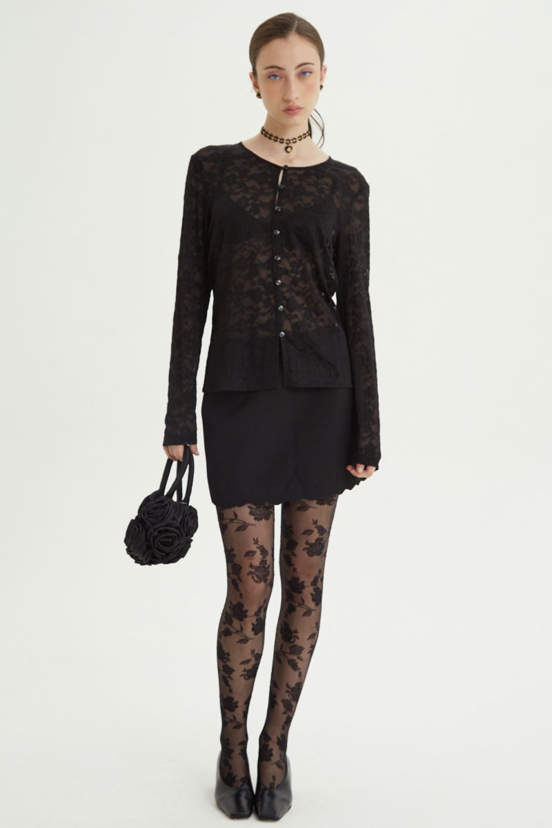 Mini falda negro sastrera tiro medio de silueta recta con terminación ondulada en el ruedo. 
