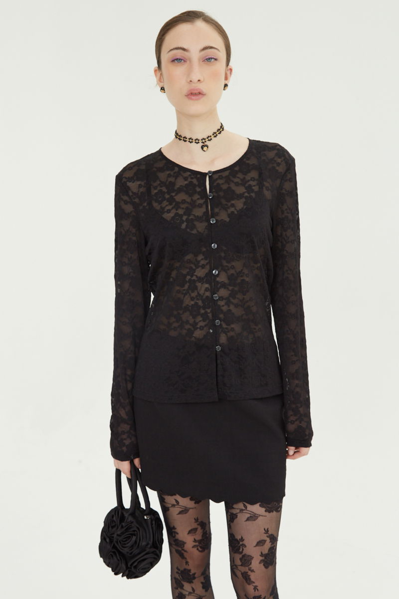 Mini falda negro sastrera tiro medio de silueta recta con terminación ondulada en el ruedo. 
