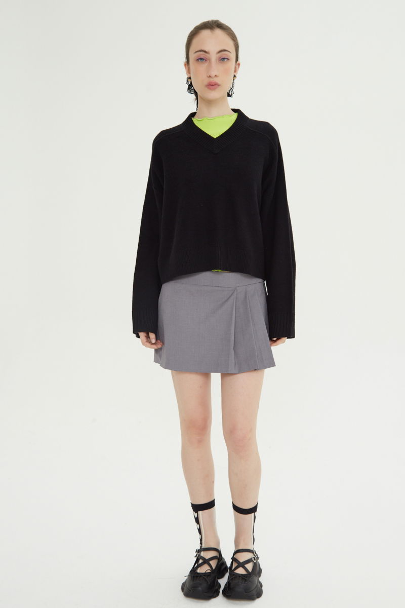 Short sastrero gris tiro bajo y corto con falda tableada superpuesta al frente y pinzas traseras.
