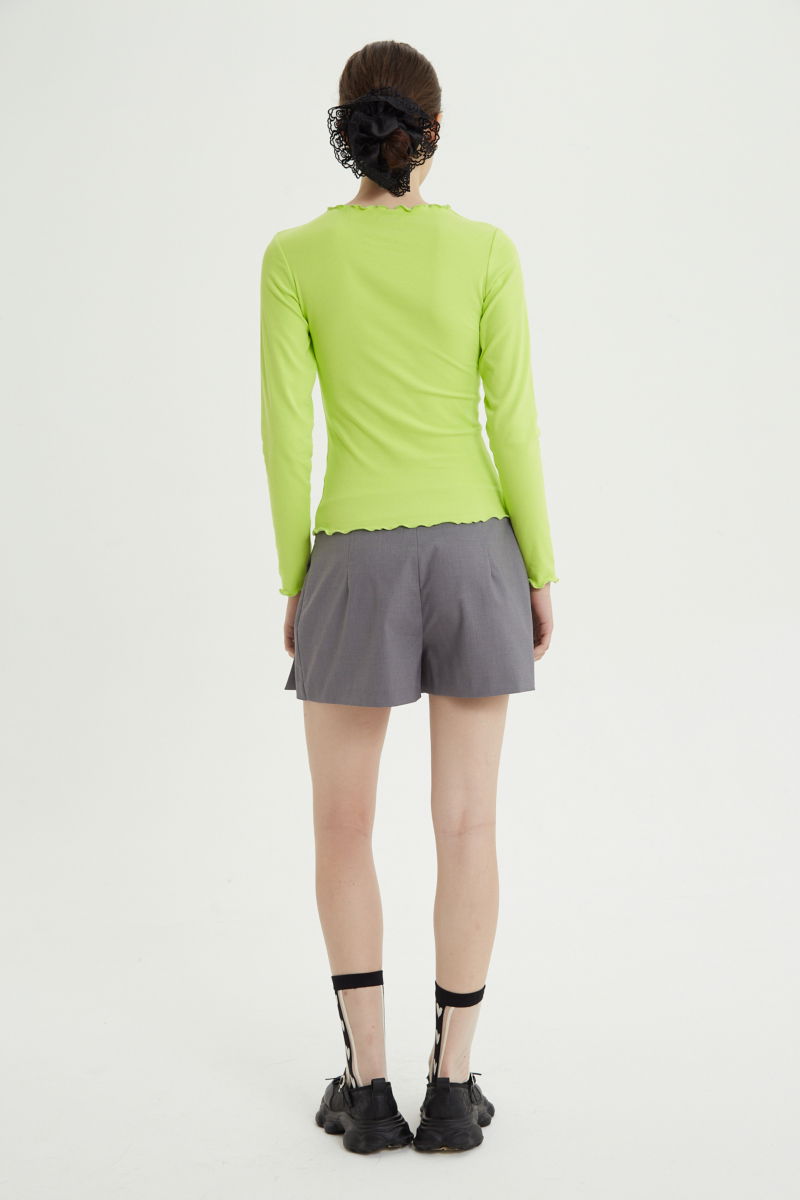 Short sastrero gris tiro bajo y corto con falda tableada superpuesta al frente y pinzas traseras.
