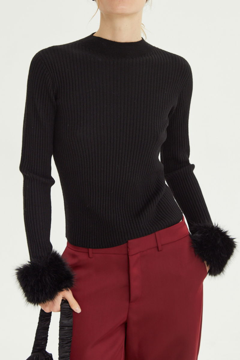 Sweater negro de morley al cuerpo con cuello redondo y puños de pelo. 