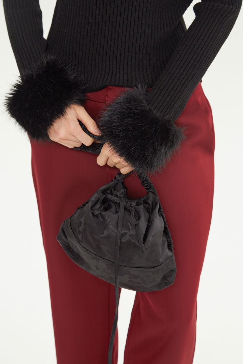 Sweater negro de morley al cuerpo con cuello redondo y puños de pelo. 