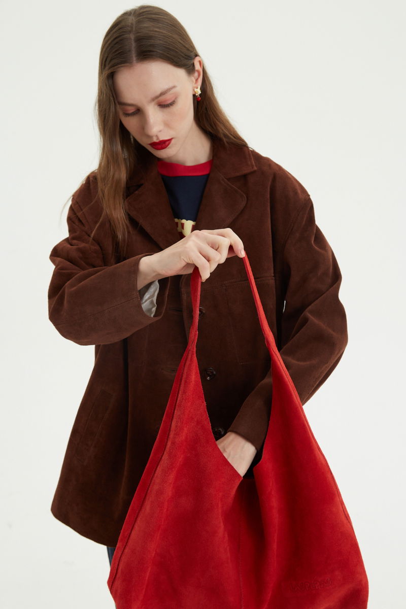 Maxi cartera roja de gamuza con broche con imán, logo de Las Pepas en el frente y bolso interno de red desmontable. 