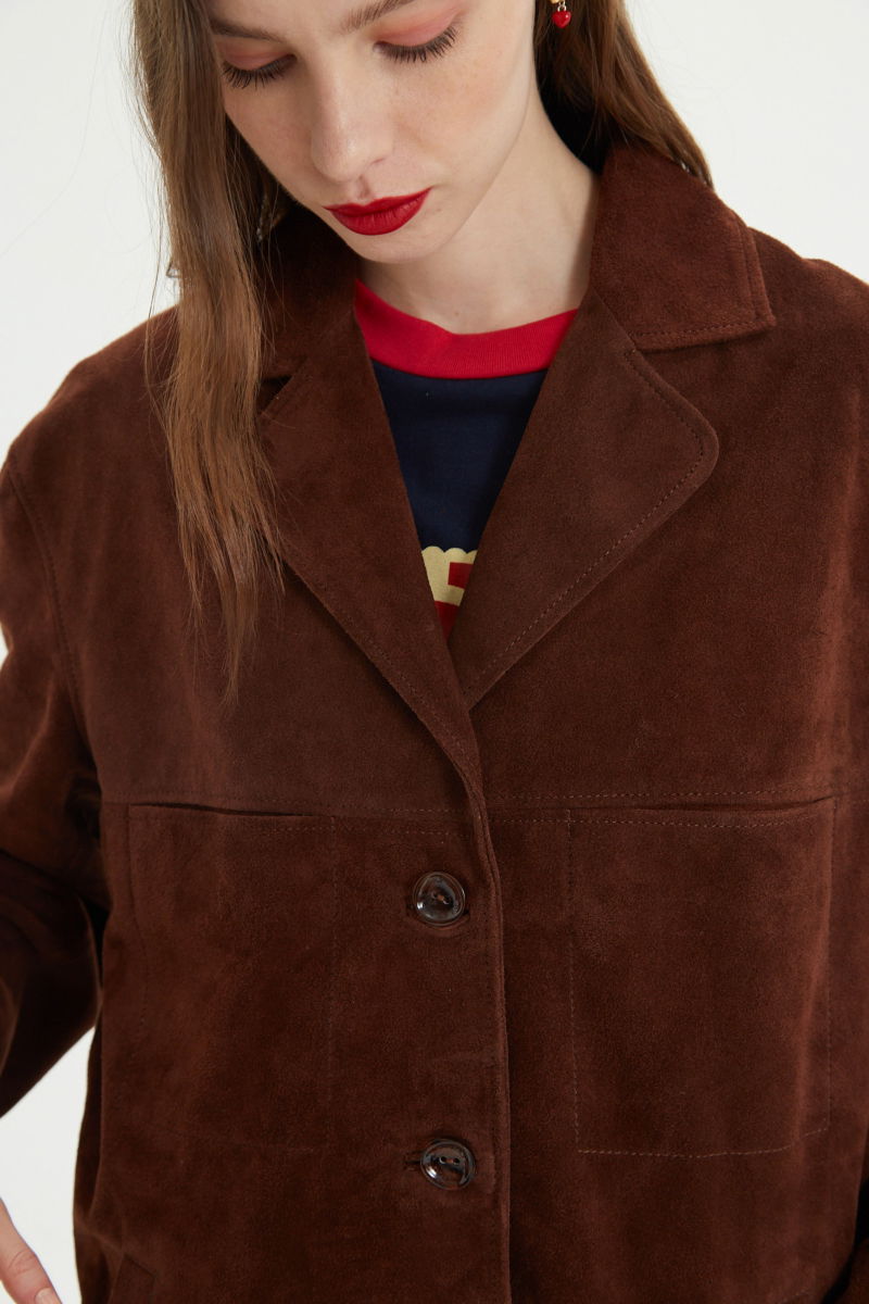 Saco oversize de gamuza largo debajo de la cadera con botones nacarados, bolsillos frontales y laterales y recortes. 
