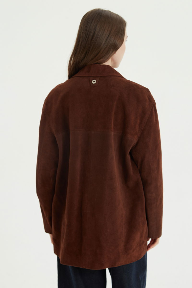 Saco oversize de gamuza largo debajo de la cadera con botones nacarados, bolsillos frontales y laterales y recortes. 
