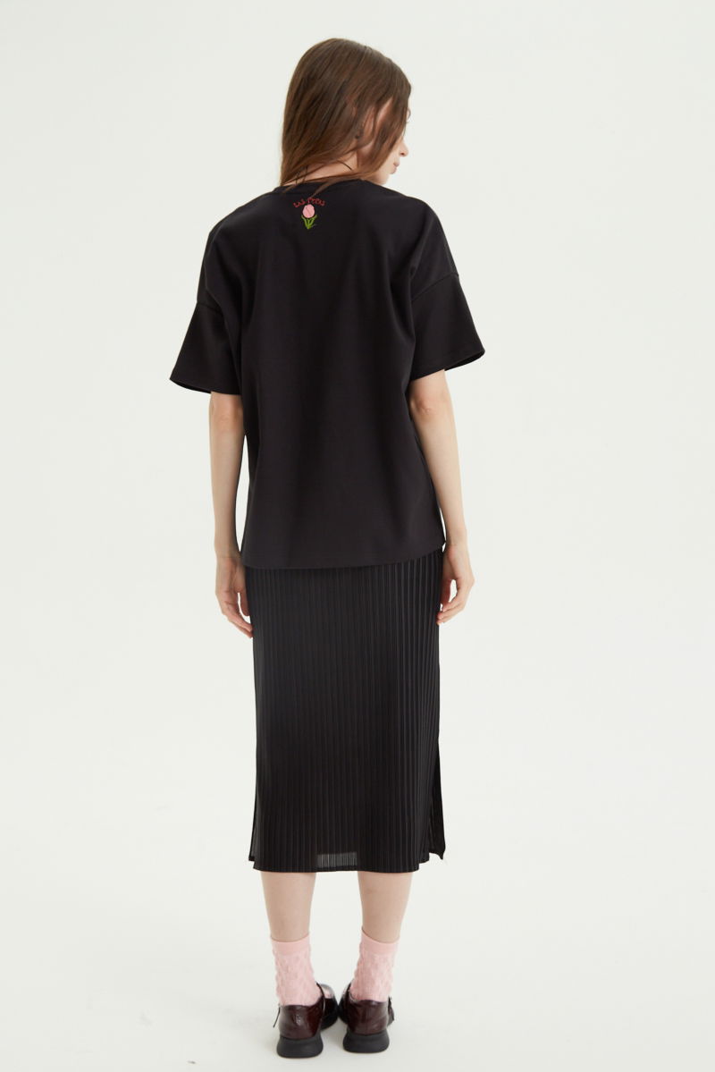 Falda negra midi plisada satinada con elástico en la cintura. Su fit es entallado, se estira y se adapta al cuerpo, con tajos laterales en el ruedo