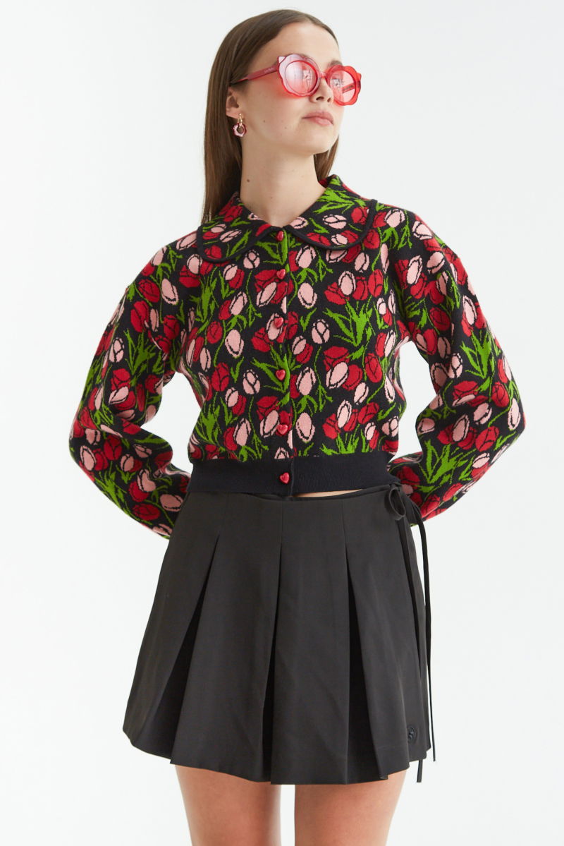 Falda negra sastrera acampanada con sobre falda tableada con lazo para atar en el lateral. 