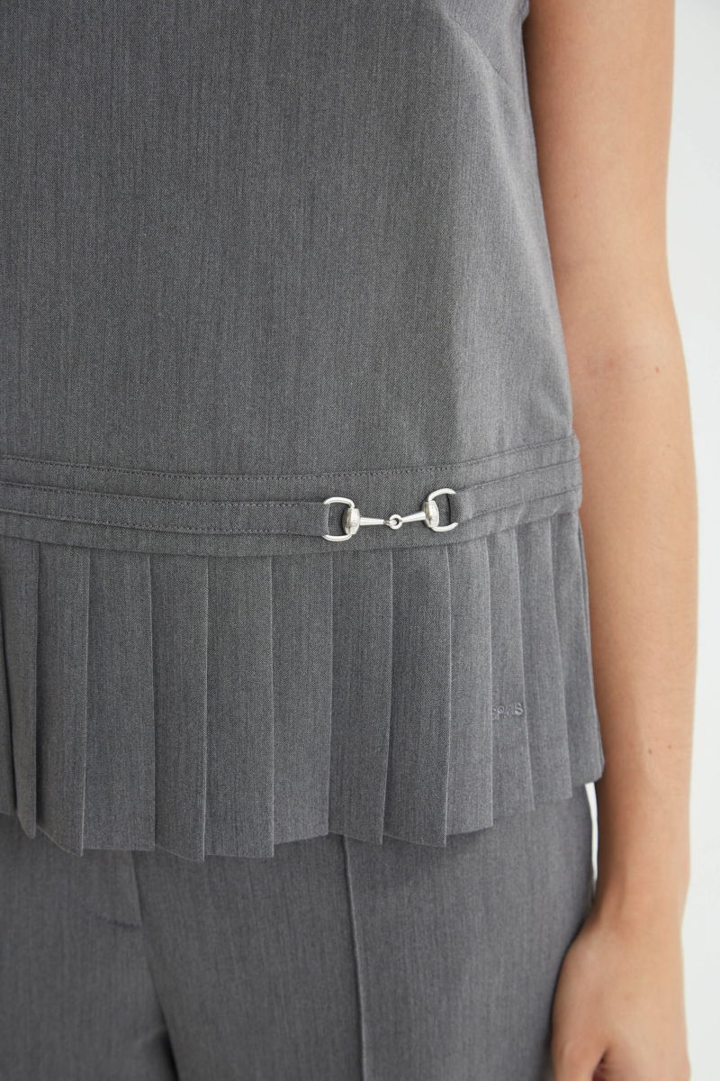 Blusa gris sastrera sin mangas con tablas en la cintura, herrajes metálicos y escote a la base del cuello, larga a la cadera. 