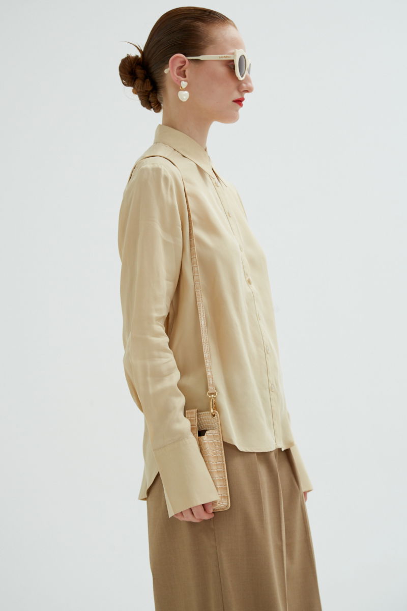 Camisa beige de calce recto y puños anchos con textura suave de piel de durazno. 
