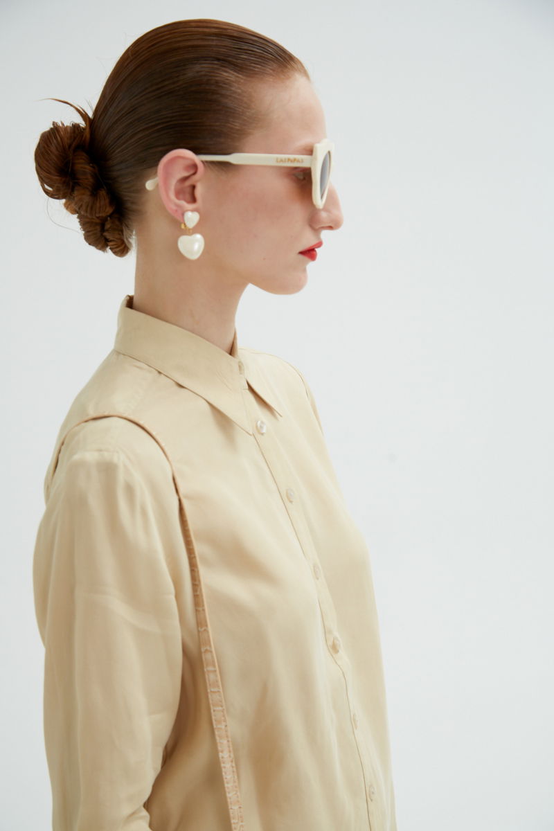 Camisa beige de calce recto y puños anchos con textura suave de piel de durazno. 
