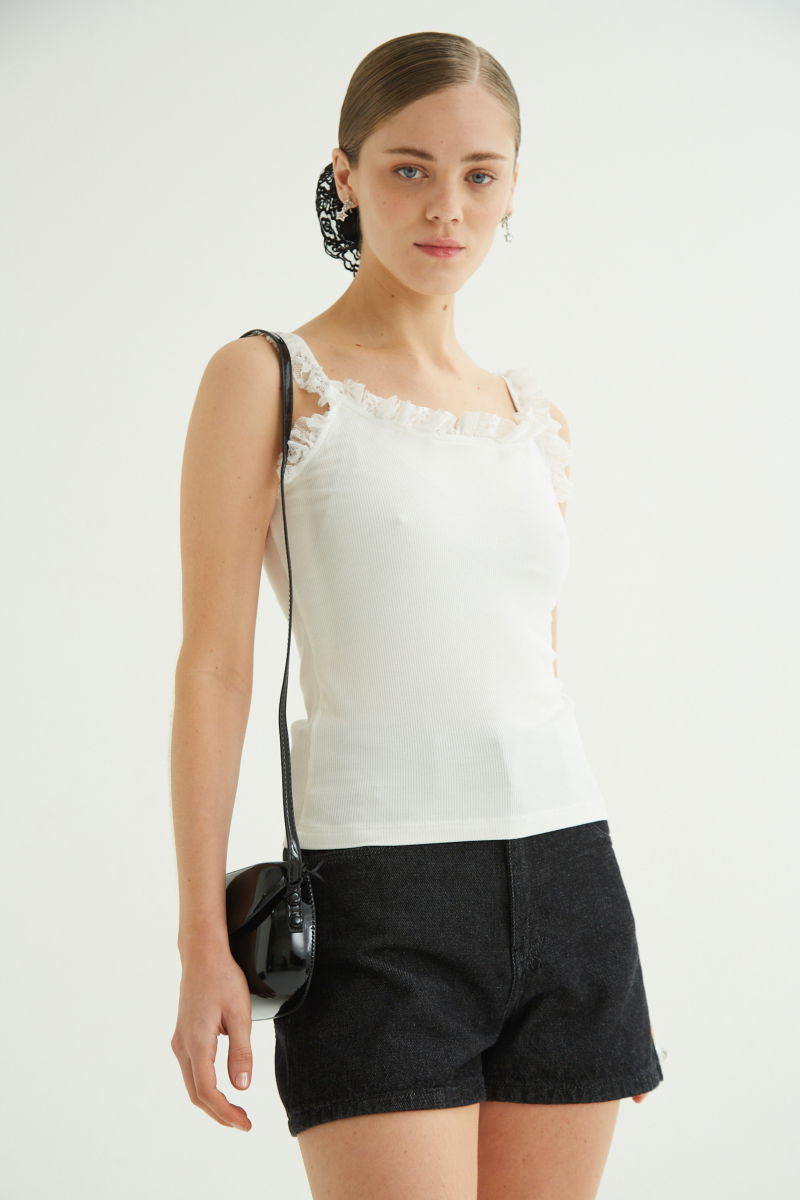 Musculosa negra de morley con breteles finos y cuello con volados de encaje.
