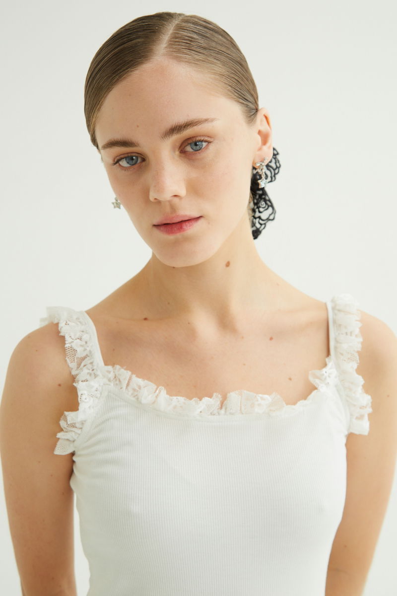 Musculosa negra de morley con breteles finos y cuello con volados de encaje.
