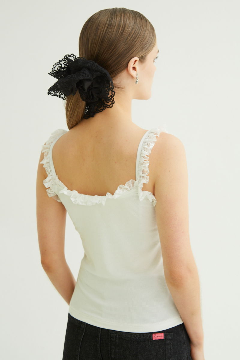 Musculosa negra de morley con breteles finos y cuello con volados de encaje.
