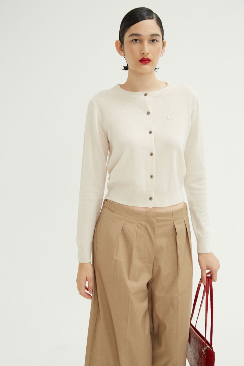 Cardigan crudo de lana y cachemira de corte recto entallado en la cintura con terminaciones en rib en puños y ruedo, cuello redondo cerrado y botones a tono.