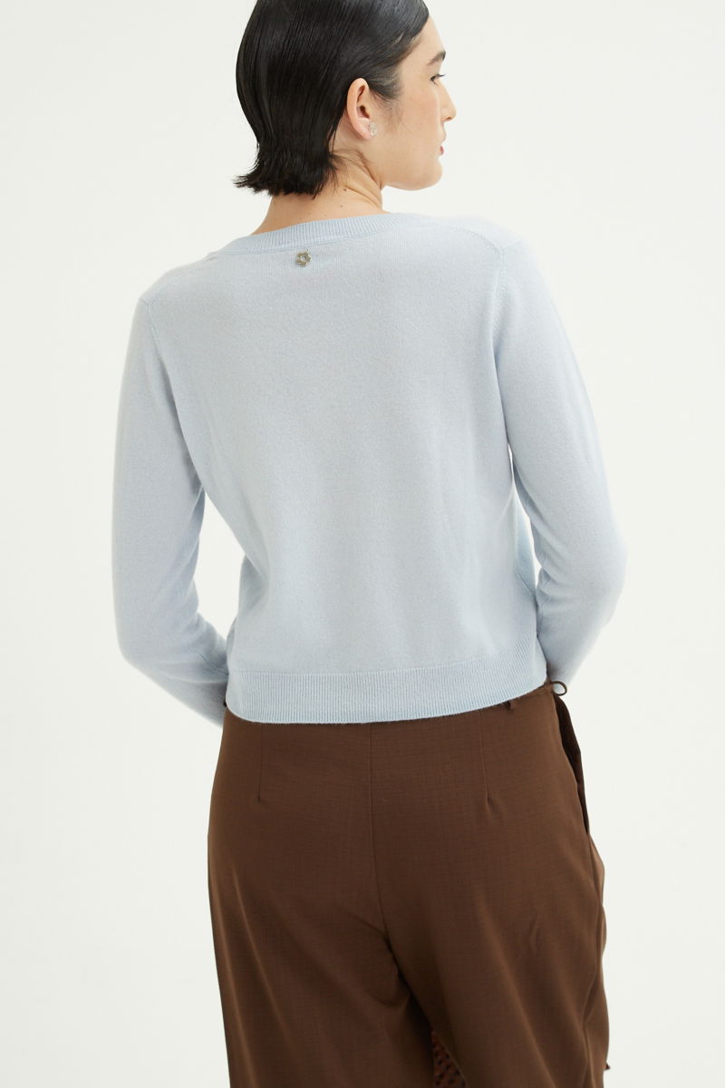 Sweater celeste de lana y cachemira recto y entallado en la cintura con cuello redondo y terminaciones de ribb en puños y ruedo.