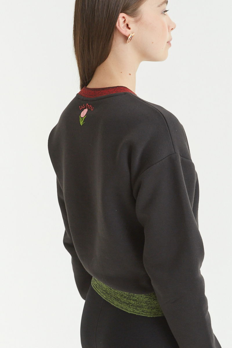 Buzo con estampa de tulipanes en relieve, recto y largo a la cadera con hombros caídos y terminaciones de rib jaspeado a contratono en cuello, puños y ruedo.