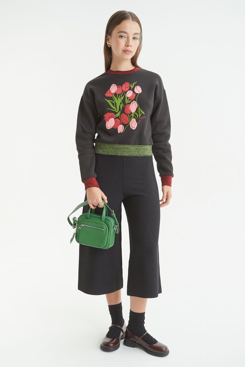 Pantalón negro tejido tiro alto y de calce recto con cintura elástica, piernas anchas y largo por arriba de los tobillos. 