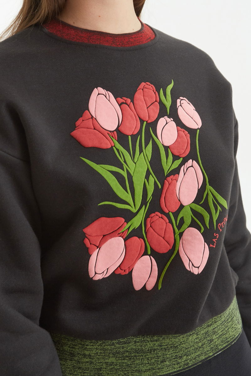 Buzo con estampa de tulipanes en relieve, recto y largo a la cadera con hombros caídos y terminaciones de rib jaspeado a contratono en cuello, puños y ruedo.