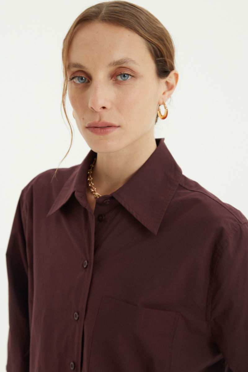 Camisa uva oversize de poplín de algodón larga por debajo de la cadera con bolsillo aplicado al frente, tabla en la espalda y botones a tono.