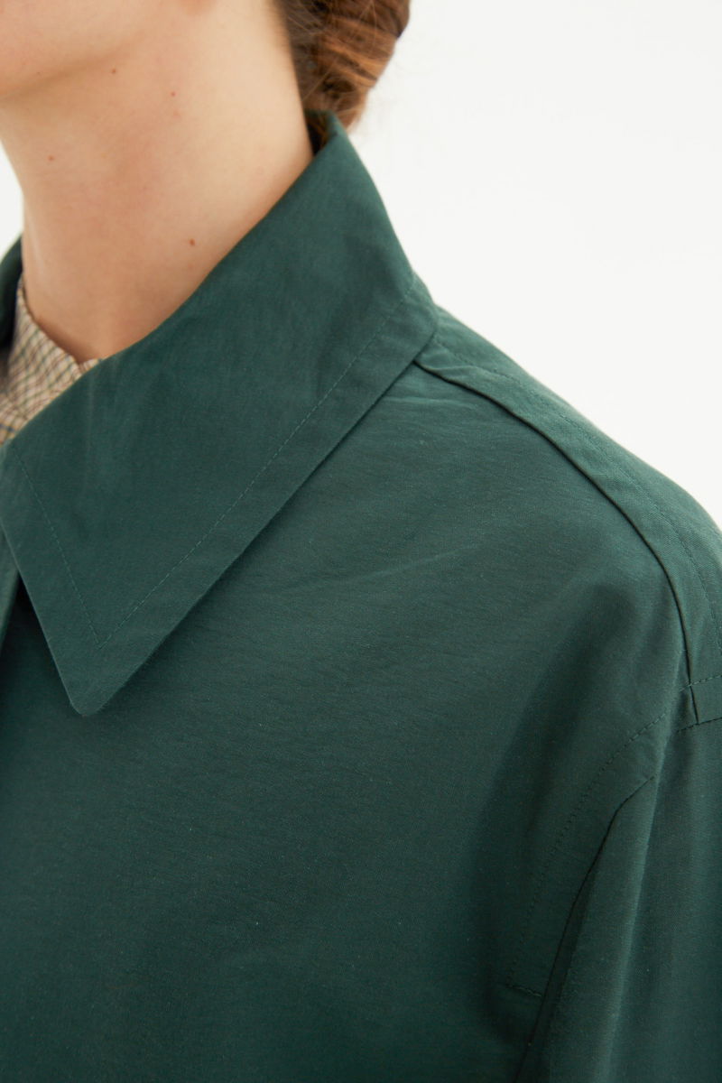 Saco verde liviano recto y largo por arriba de las rodillas con cierre, broches snap y cinturon. 
