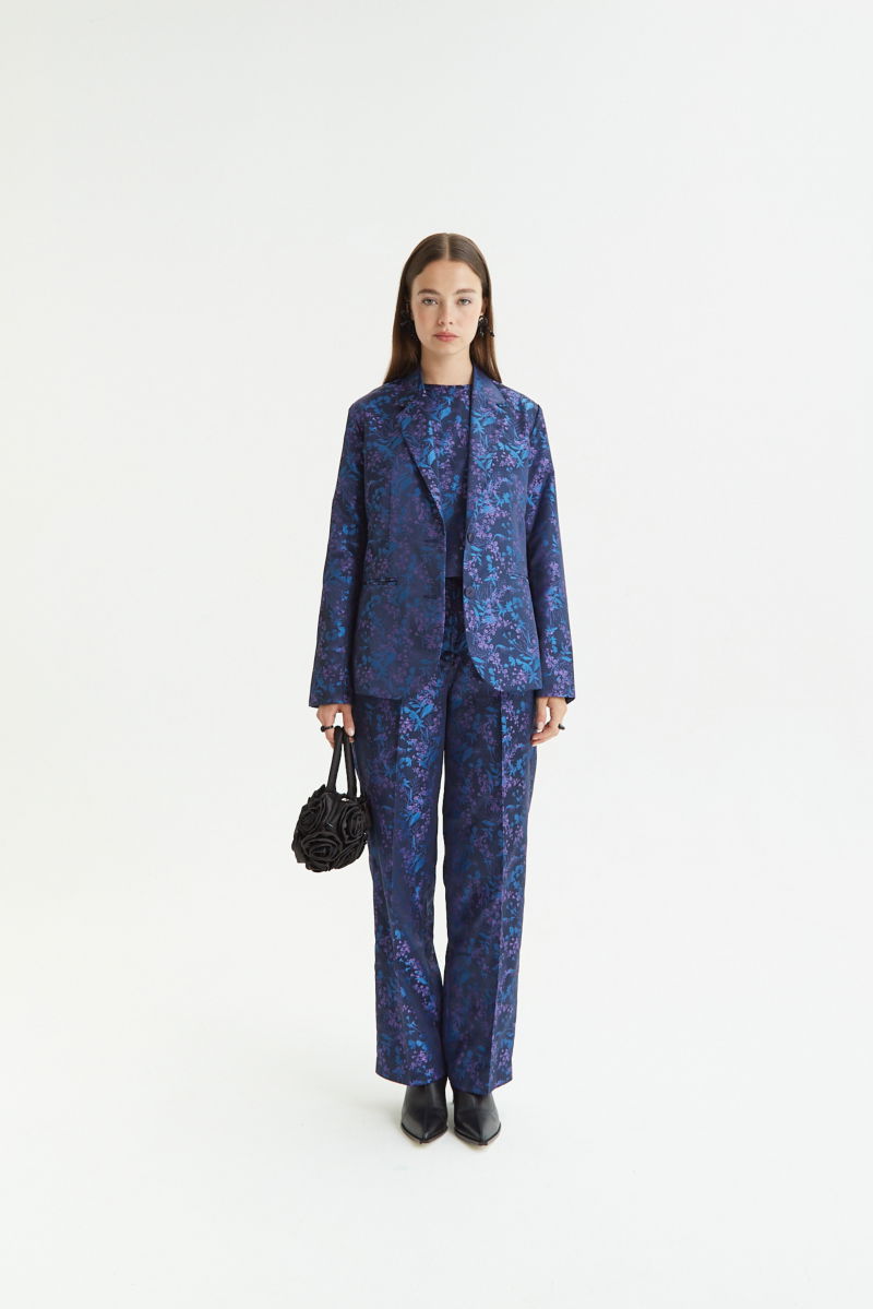 Saco azul sastrero recto de jacquard satinado con hombreras, solapa con cruce recto y botones tornasolados. 
