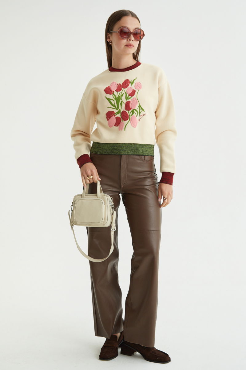 Buzo con estampa de tulipanes en relieve, recto y largo a la cadera con hombros caídos y terminaciones de rib jaspeado a contratono en cuello, puños y ruedo.