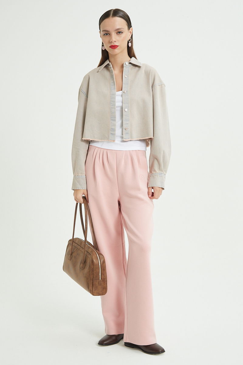 Camisa rosa amplia y crop de jean con ruedo desflecado.
