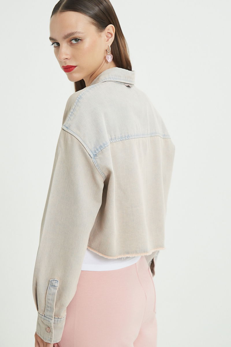 Camisa rosa amplia y crop de jean con ruedo desflecado
