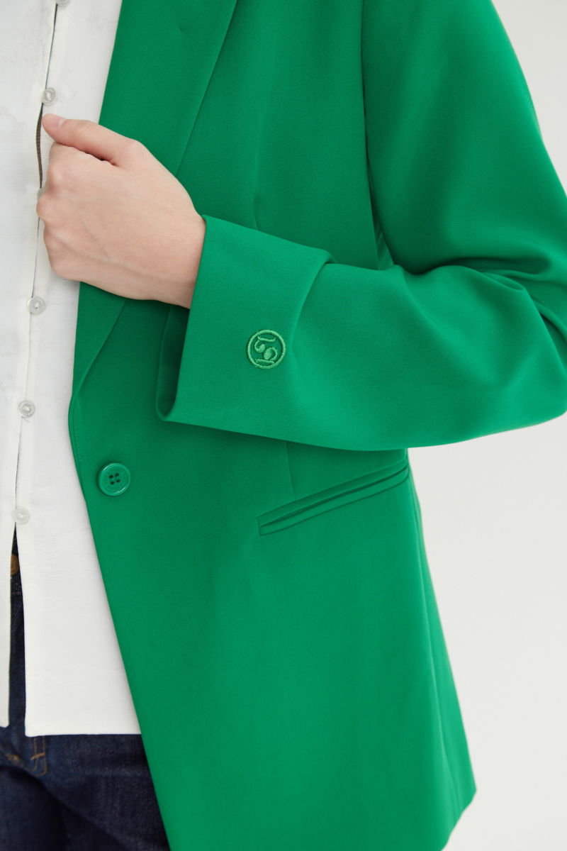 Blazer verde sastrero recto con hombreras, bolsillos ojal y pinzas en frente y espalda. 
