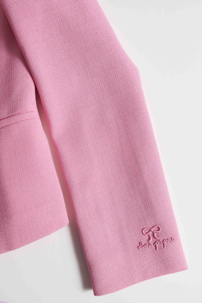 Blazer rosa sastrero entallado con terminación ondulada y mangas princesa. 
