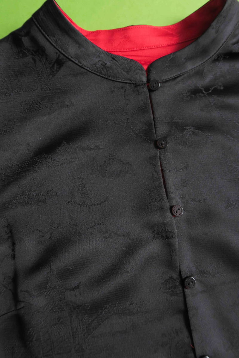 Blusa negra reversible de jacquard satinado sin mangas con cuello mao, botones a tono, pinzas frontales y aberturas laterales.