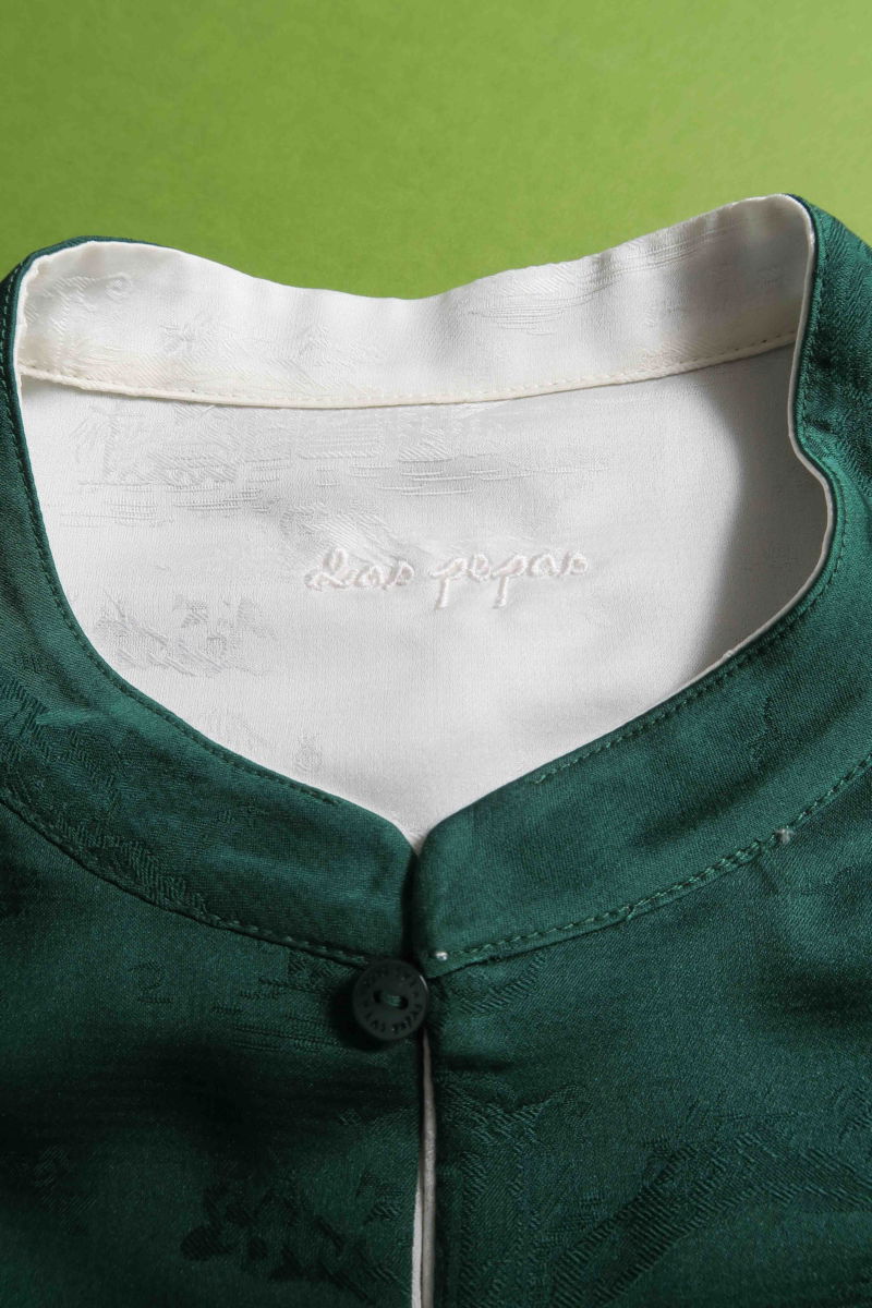 Blusa cruda reversible de jacquard satinado sin mangas con cuello mao, botones a tono, pinzas frontales y aberturas laterales.