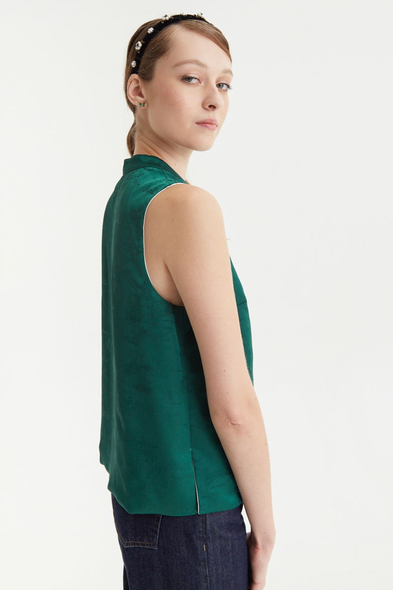 Blusa cruda reversible de jacquard satinado sin mangas con cuello mao, botones a tono, pinzas frontales y aberturas laterales.